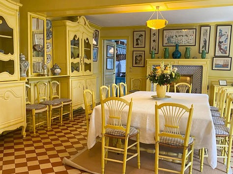 yellow dining room., blue kitchen, stairwell, two beds with canopy, living room and stairwell with tiles