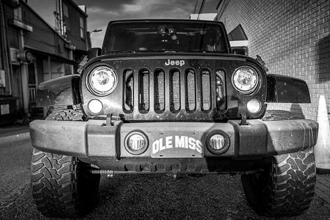 unique scenes around campus and nearby Oxford including Jeep with Ole Miss plates, iron fence, silo, shop doors and windows, bookstore, stairway with "faulkner" and "music" painted on risers
