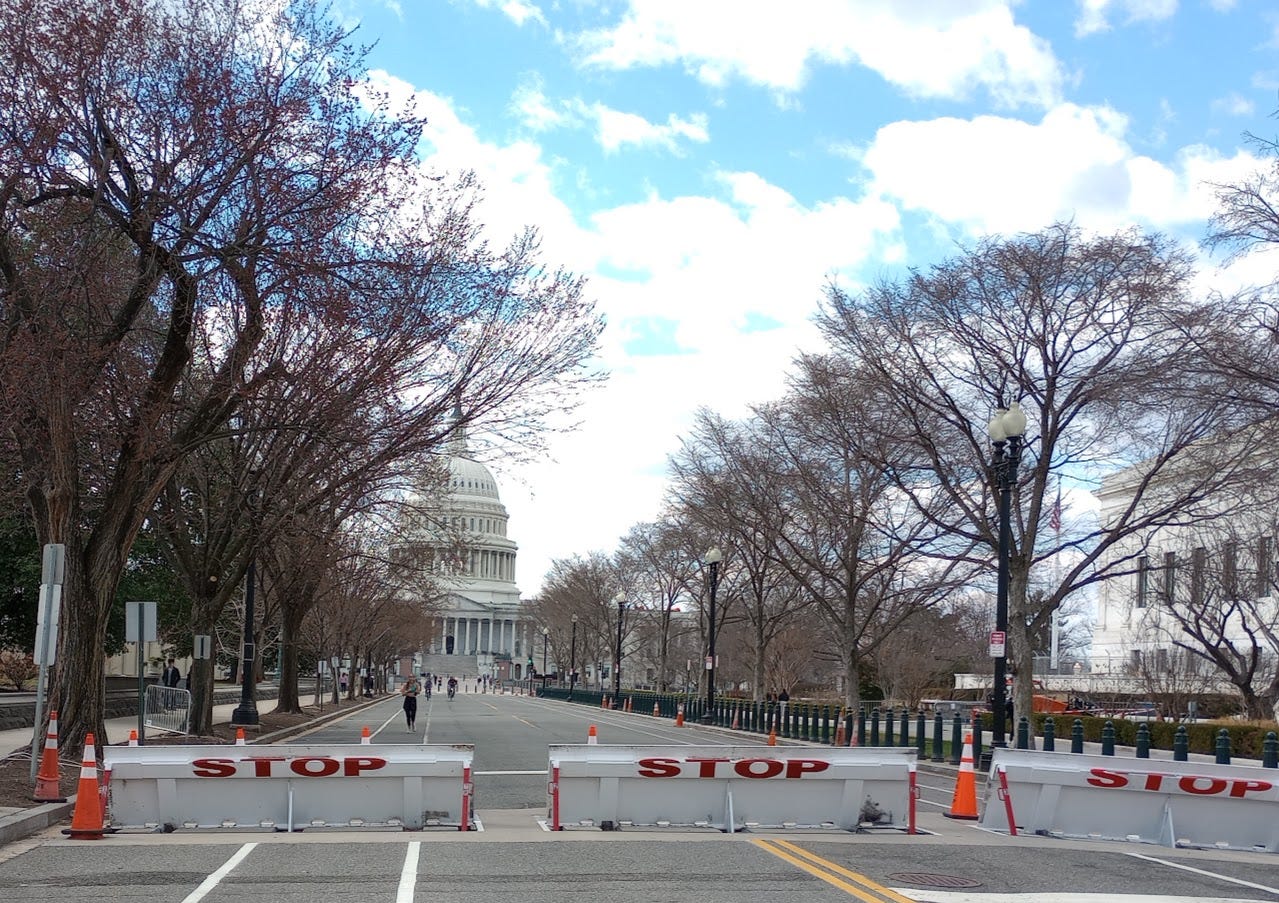 Dome of US Capitol, behind barriers marked STOP on road Dome of US Capitol, behind barriers marked STOP on road