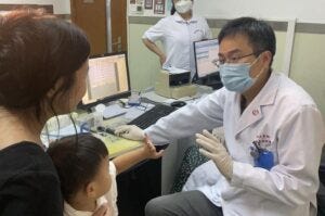 Dr. Yilai Shu communicates with a young patient at the Eye & ENT Hospital of Fudan University in Shanghai, China. Dr. Yilai Shu communicates with a young patient at the Eye & ENT Hospital of Fudan University in Shanghai, China.