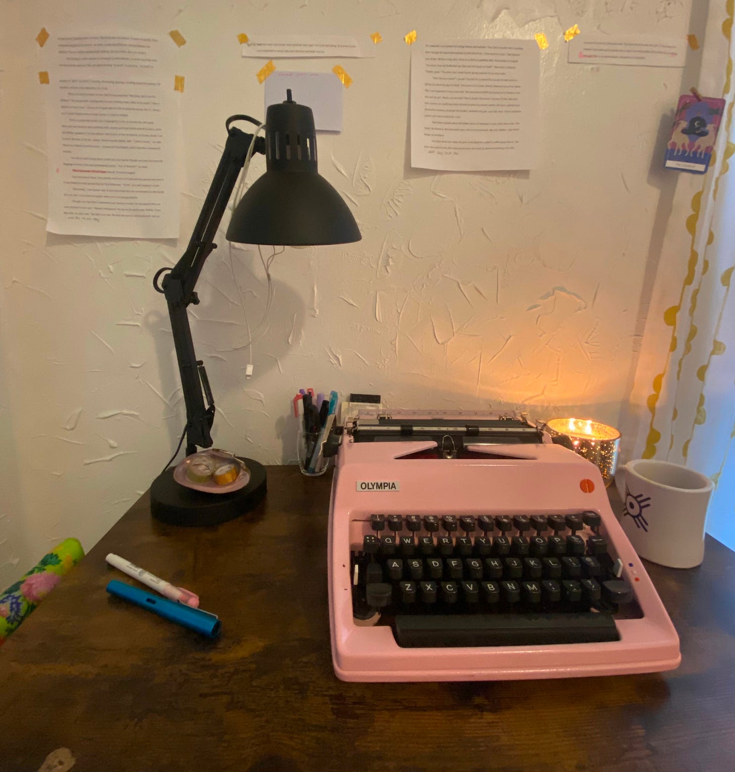 Pink typewriter on a cheap desk in front of a stucco wall. Pink typewriter on a cheap desk in front of a stucco wall.