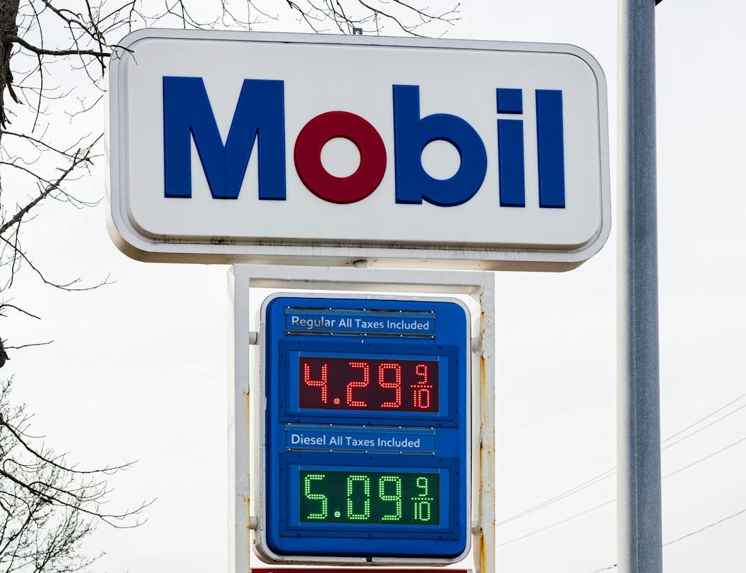 a sign for a gas station with a clock on it