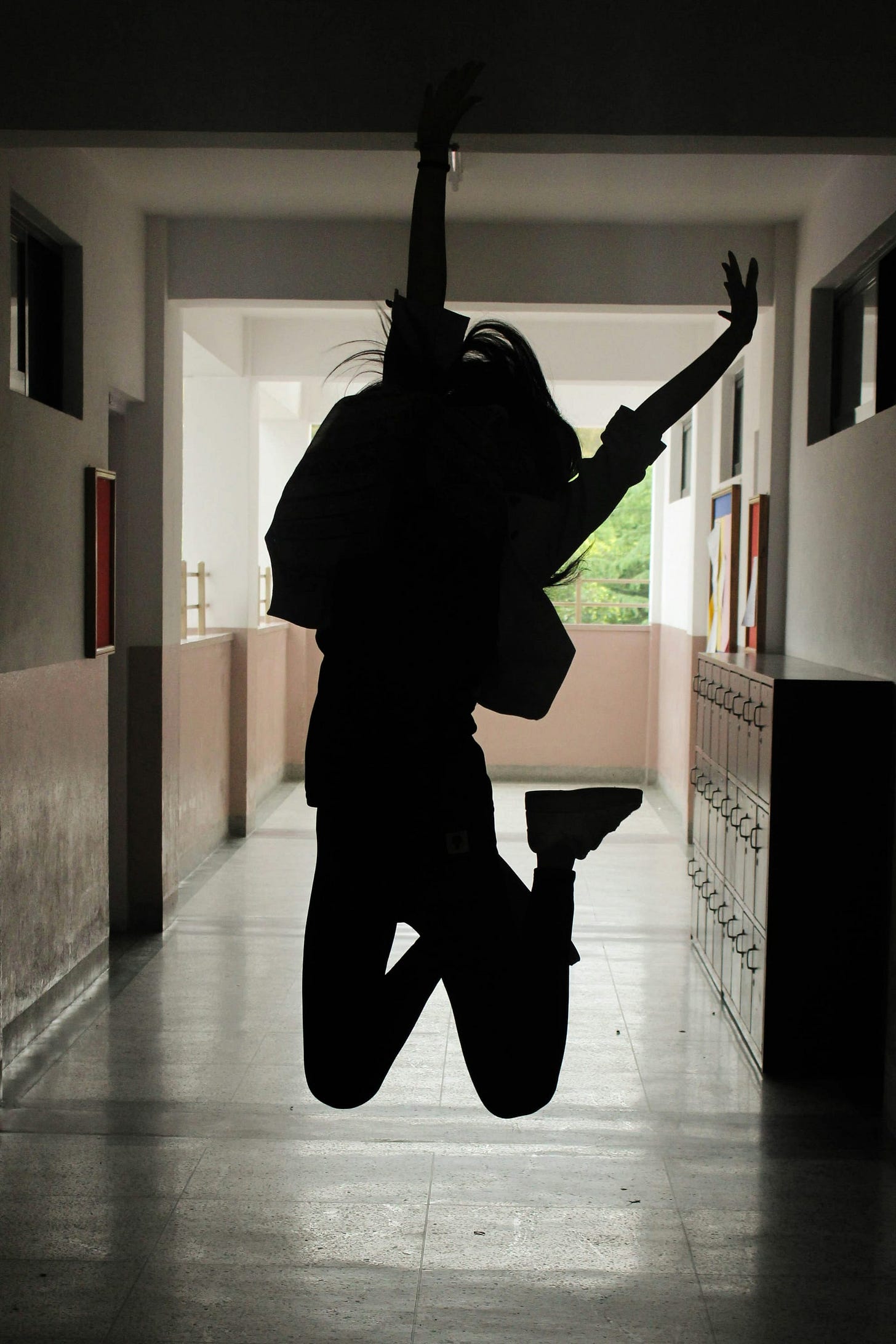 Image of a person jumping into the air in a darkened hallway