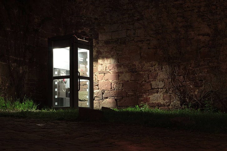 Royalty-Free photo: Phone booth near brown brick wall | PickPik