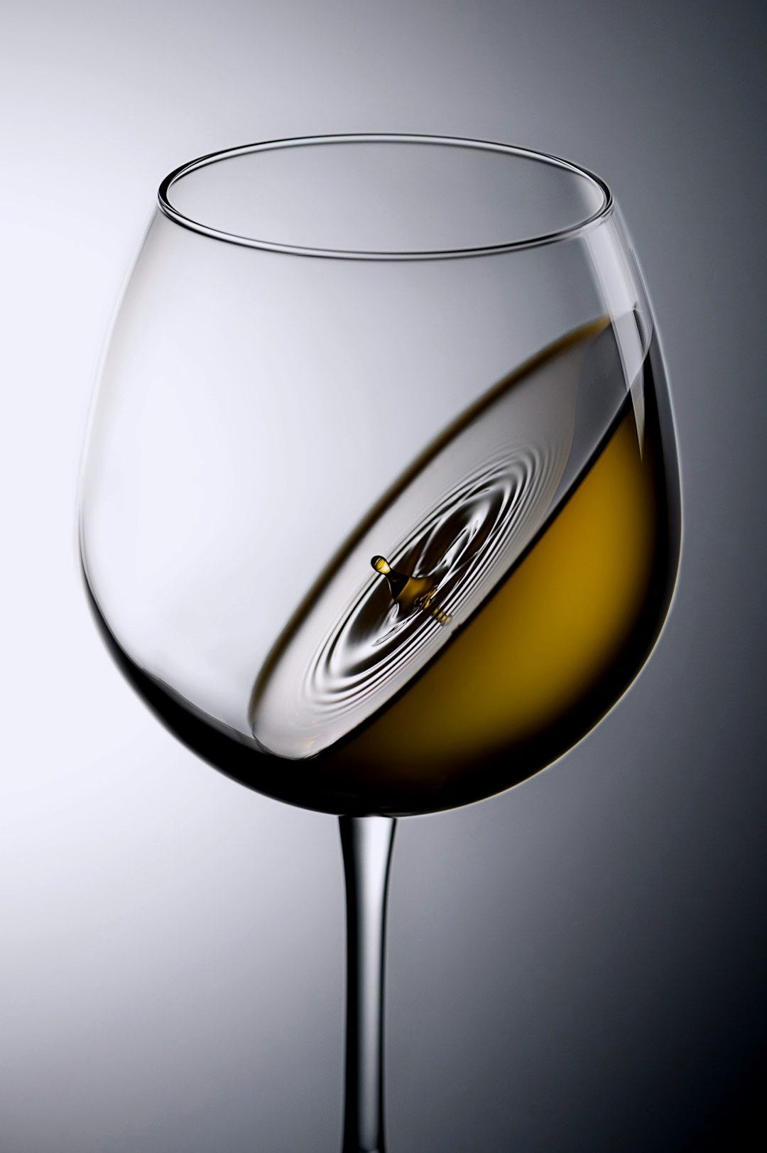 clear wine glass with yellow liquid