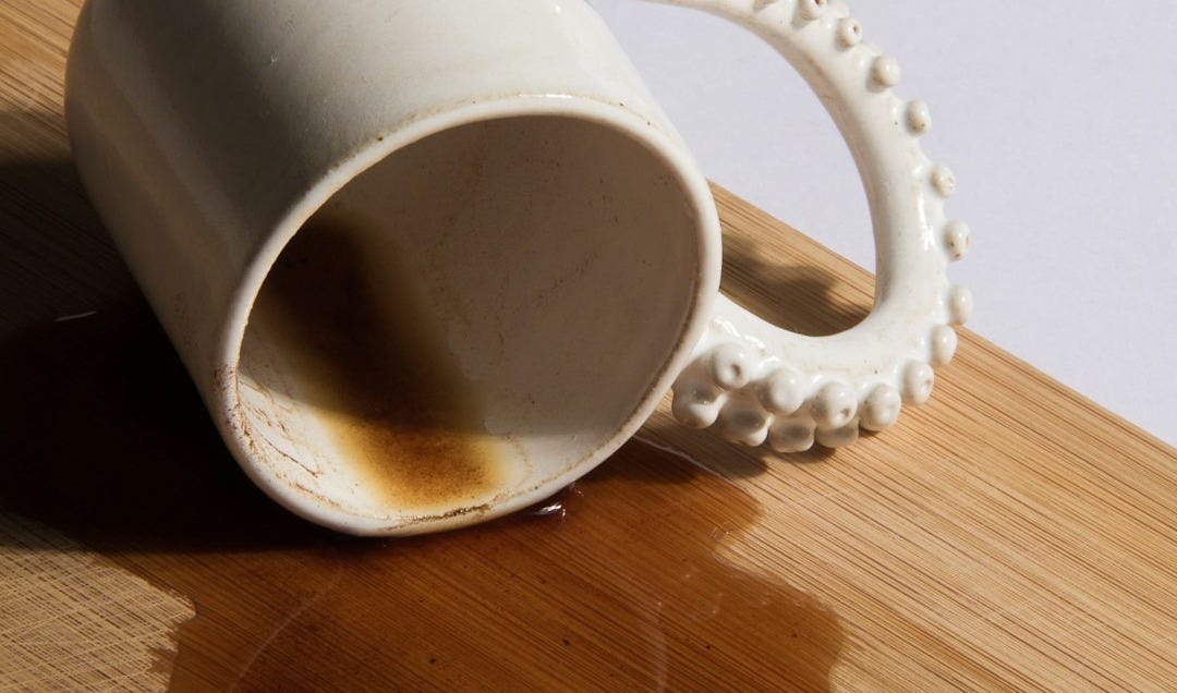 a white coffee cup sitting on top of a wooden table