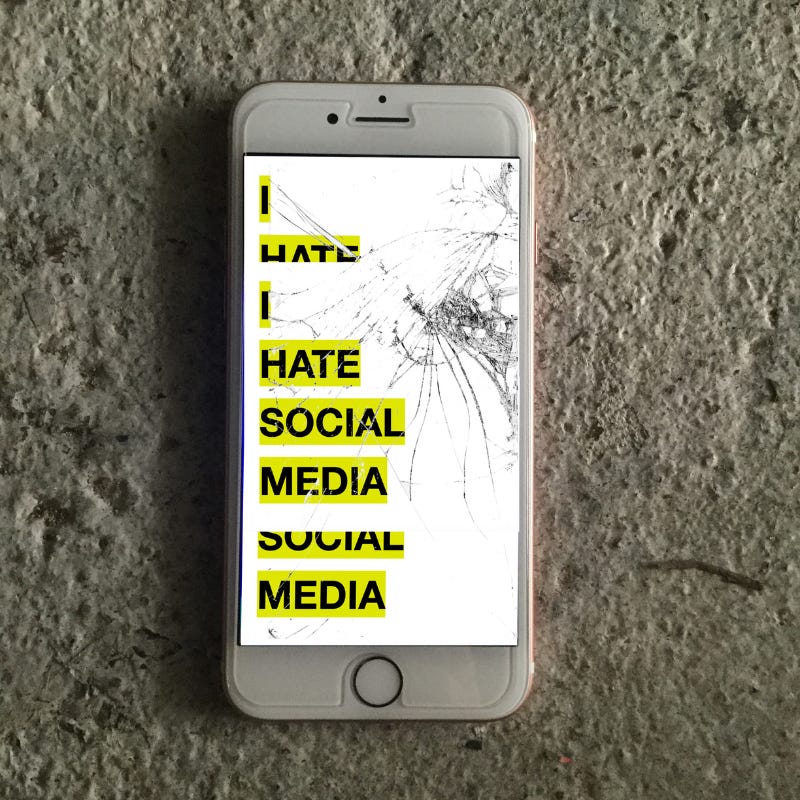 an iphone with a smashed screen reads 'i hate social media' in bold black text over white and yellow graphic.