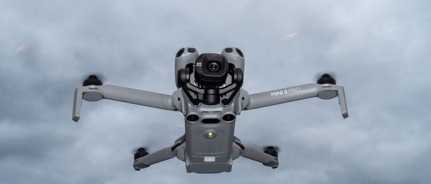 DJI Mini 5 Pro in flight against a cloudy sky DJI Mini 5 Pro in flight against a cloudy sky