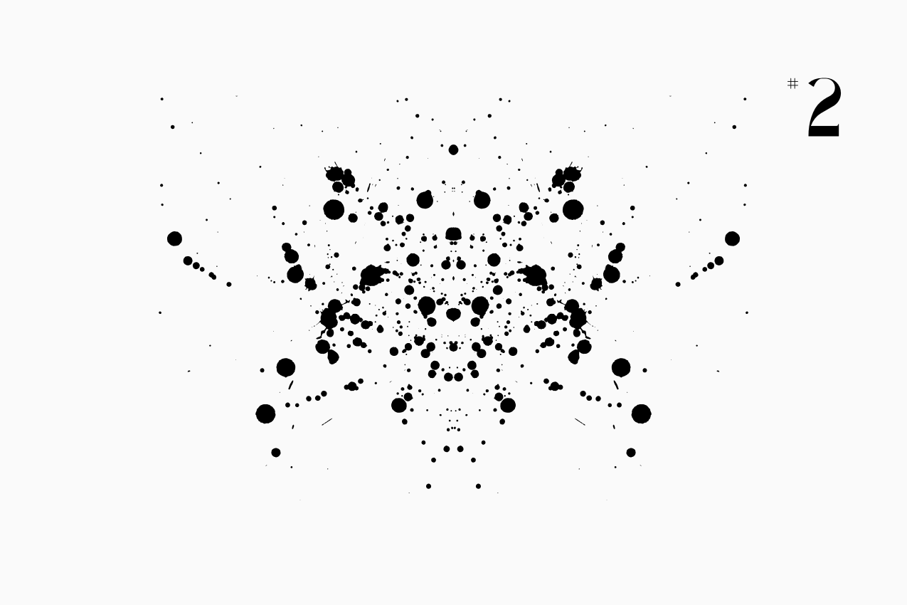 A bilateral, Rorschach-style inkblot specimen for the “In Other Words” series from The Subtext Review. The charcoal-black symmetrical splatter is centered on a cream paper background, labeled as Puzzle No. 2 in a classic serif typeface.