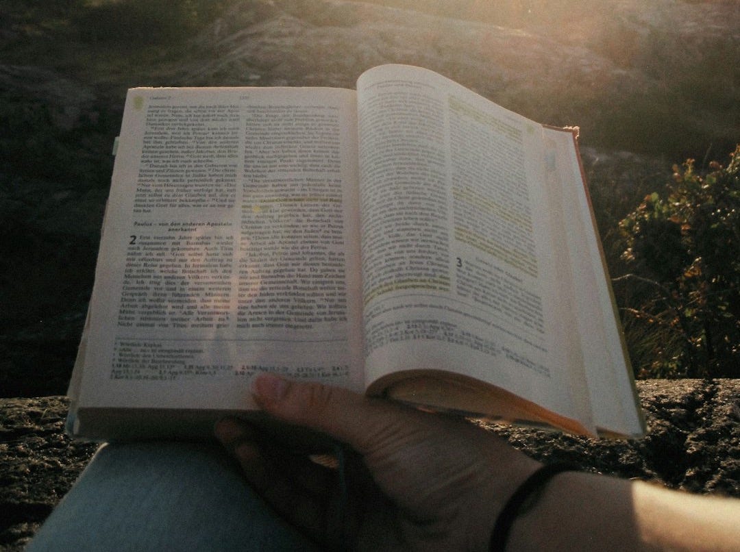 a person holding an open book in their hands