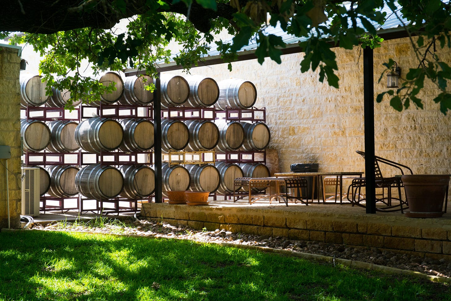Wine barrels under the trees at Becker Vineyards in the Texas Hill Country