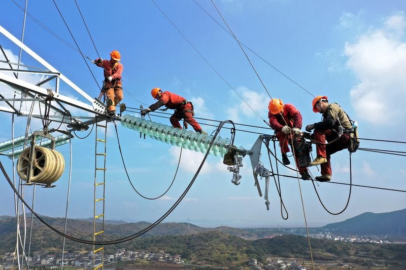Electricians work on a transmission tower in Zhejiang Province on Dec. 10.