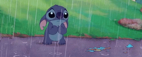 stitch from disney 's lilo and stitch is standing in the rain with a sad look on his face .