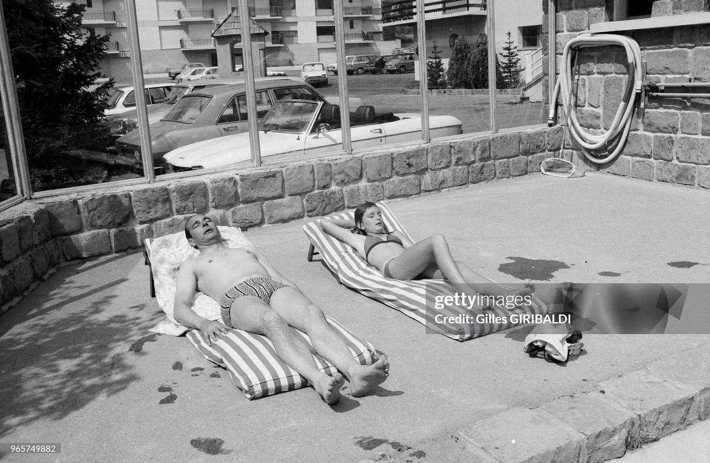 A candid moment: French Prime Minister Jacques Chirac and his daughter sunbathing next to a car park, 1974.
