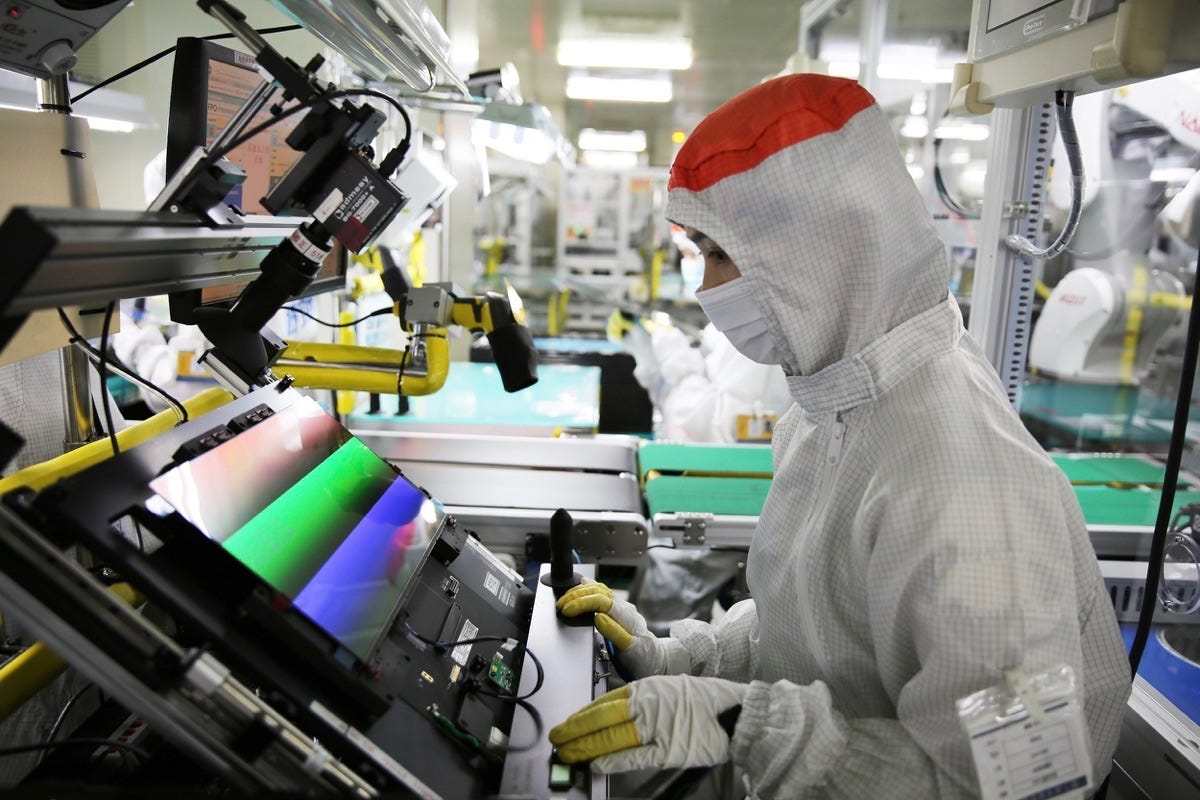 Empleado manipulando una pantalla OLED en una fábrica de Samsung Display Empleado manipulando una pantalla OLED en una fábrica de Samsung Display