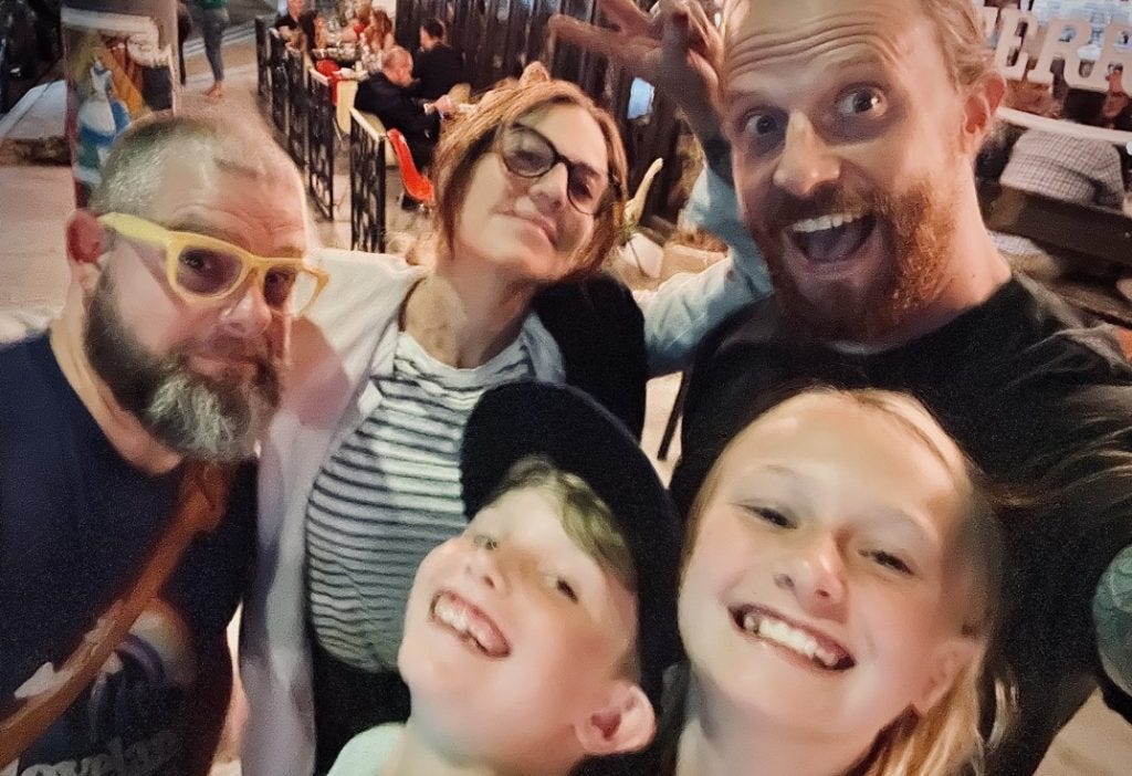 A blurry photo of five people who just ate a lot of Italian food. 