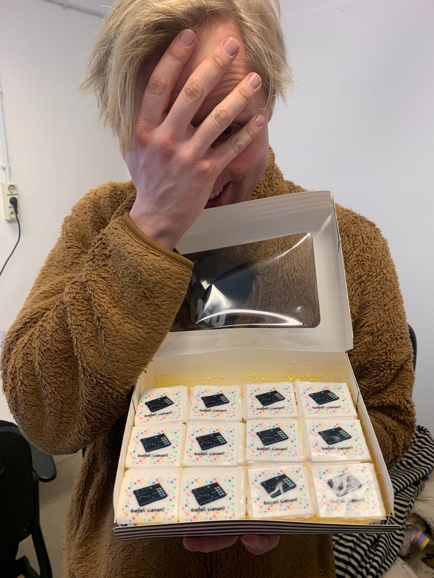 foto van lieven met zijn hoofd in zijn hand (een face-palm) en een doos met hema tompouchen er in waarop een plaatje van een rodecaster geprint staat en de tekst gefeli lieven!