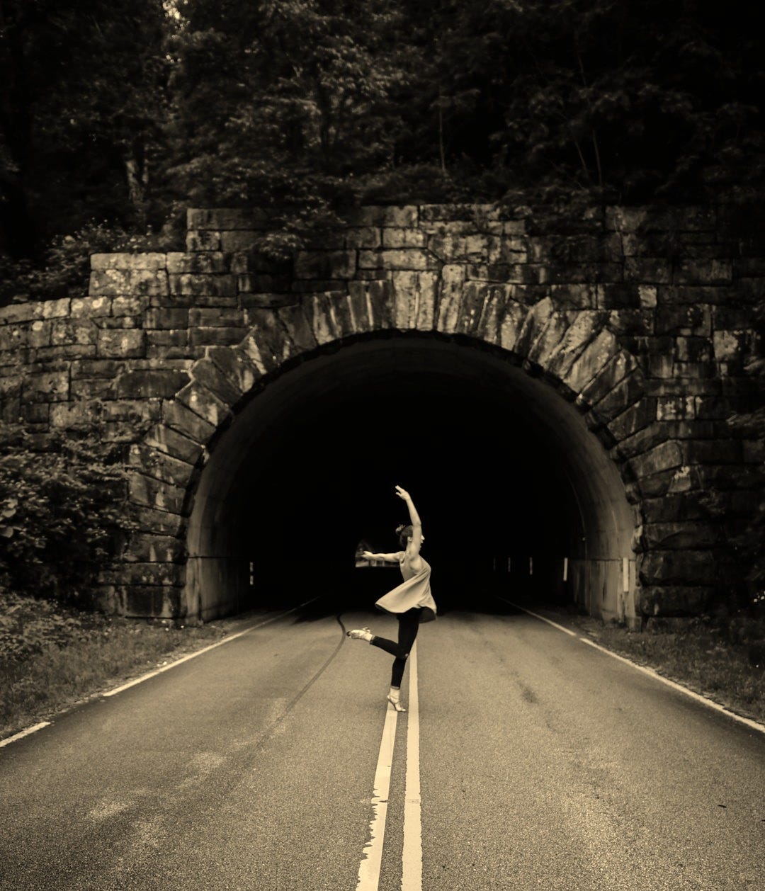 woman in ballet position nearby tunnel