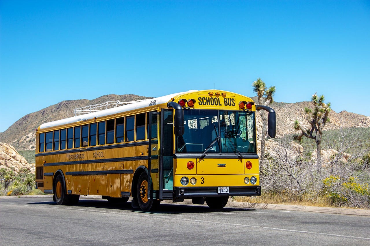 A yellow school bus in an arid landscape A yellow school bus in an arid landscape
