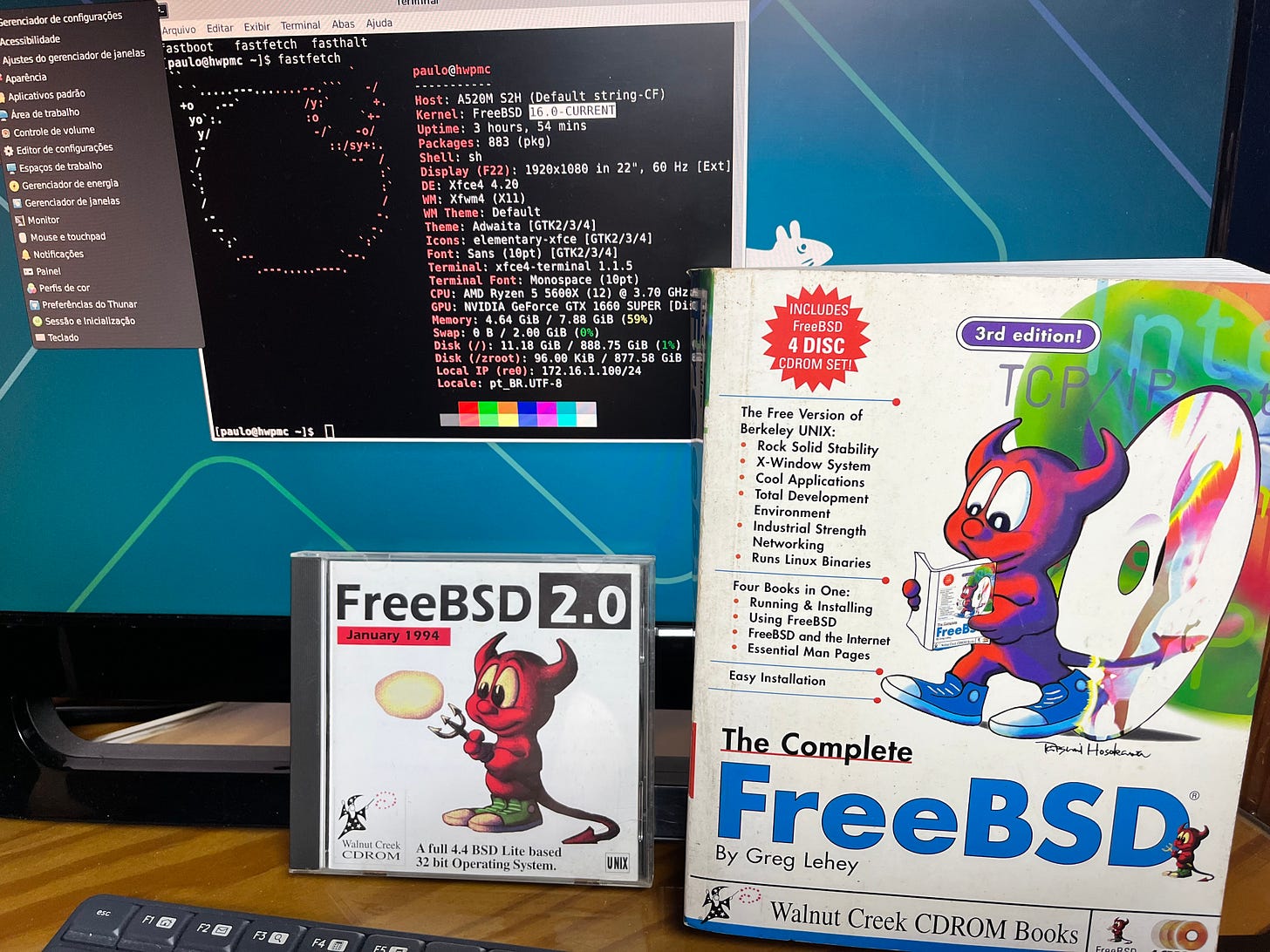 Thirty-two years of FreeBSD on one desk: a January 1994 FreeBSD 2.0 CD-ROM and "The Complete FreeBSD" book beside a live FreeBSD 16.0-CURRENT session, hostname hwpmc, on a Ryzen 5 5600X workstation in Recife. Thirty-two years of FreeBSD on one desk: a January 1994 FreeBSD 2.0 CD-ROM and "The Complete FreeBSD" book beside a live FreeBSD 16.0-CURRENT session, hostname hwpmc, on a Ryzen 5 5600X workstation in Recife.