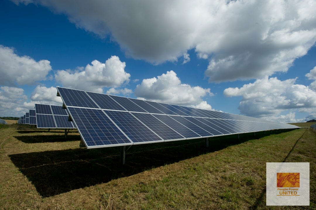 Solar panels on a green field. People Power United logo shows statue of liberty. Solar panels on a green field. People Power United logo shows statue of liberty.