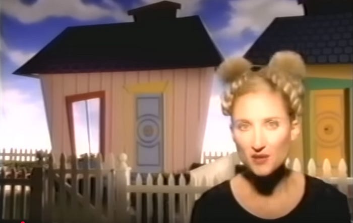 Jill Sobule with her hair in space buns in the “I Kissed a Girl” video.