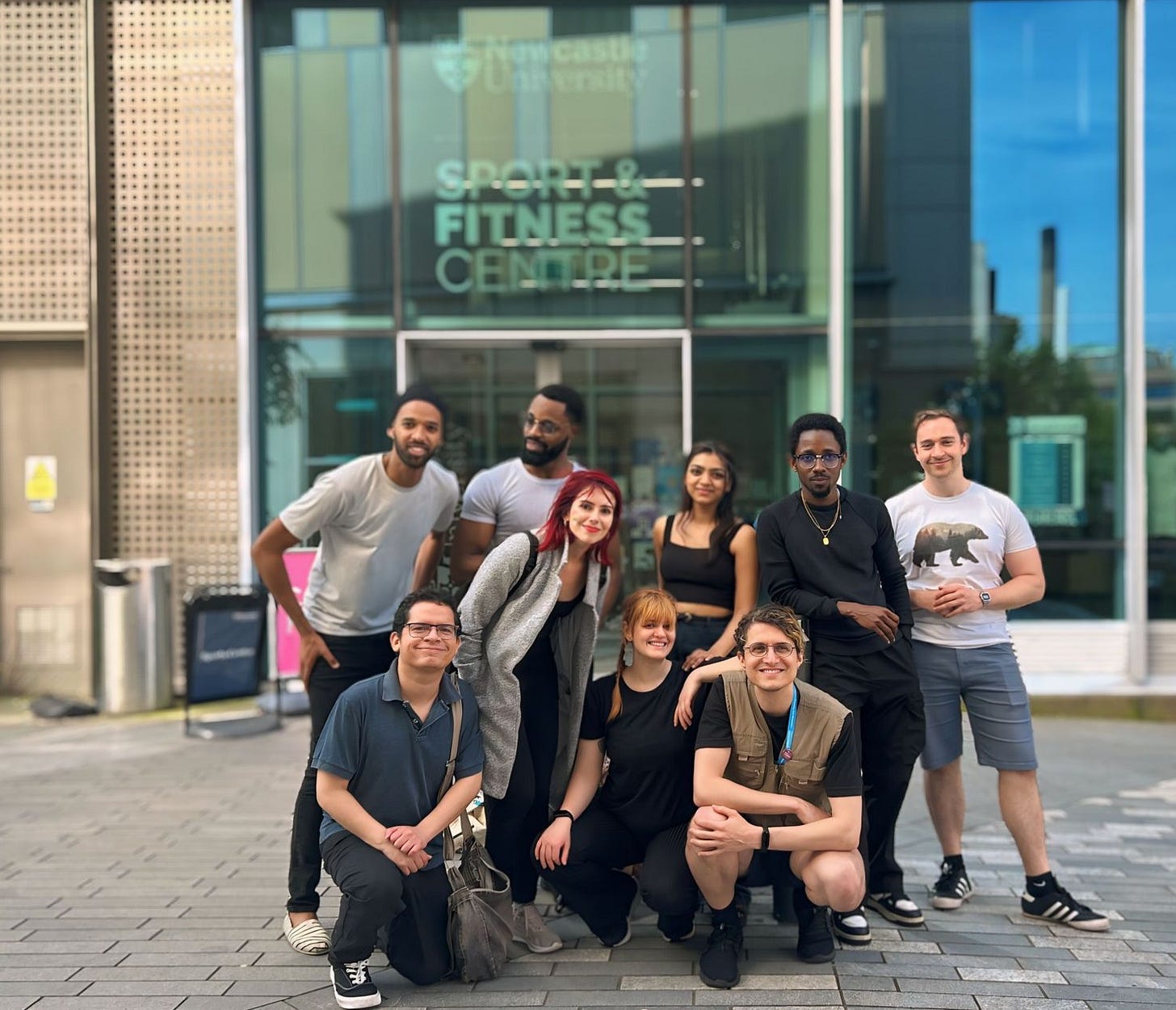 A film crew and cast in front of a building.