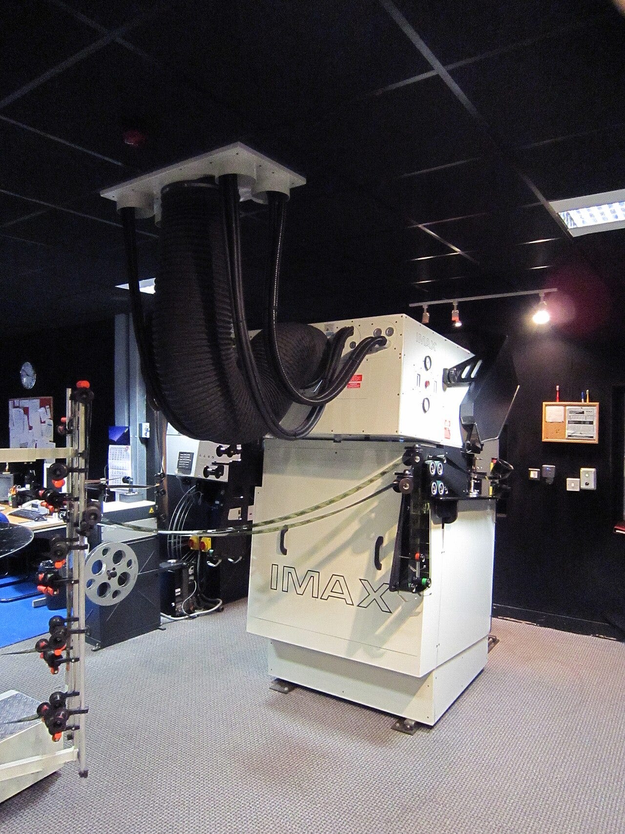 Photo: William Hook / Wikimedia Commons (CC BY-SA 2.0) The IMAX GT projector. The pipes going into the roof are to cool the overall projector and bulb. The thick one is air, the smaller ones are water. The room next to the projection room has a full pump system including a dedicated feed of water, separa
