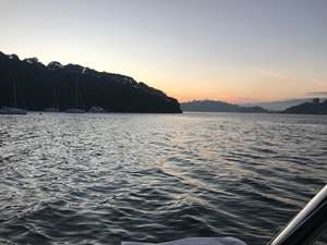 A body of water with boats in the distance

AI-generated content may be incorrect.