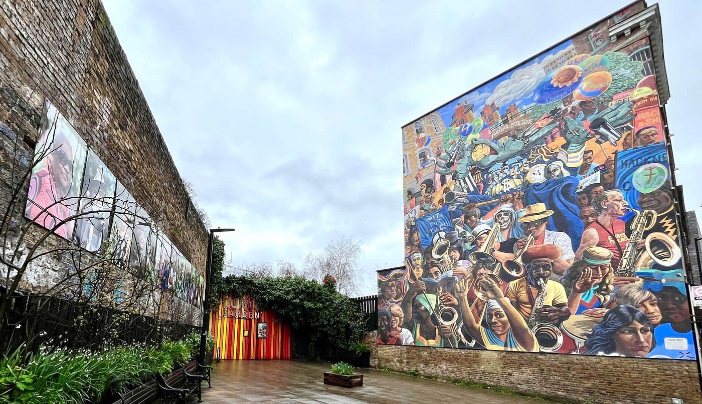 Entrance to Curve Garden, with graffiti on a big wall and natural vegetation in front of the doors Entrance to Curve Garden, with graffiti on a big wall and natural vegetation in front of the doors