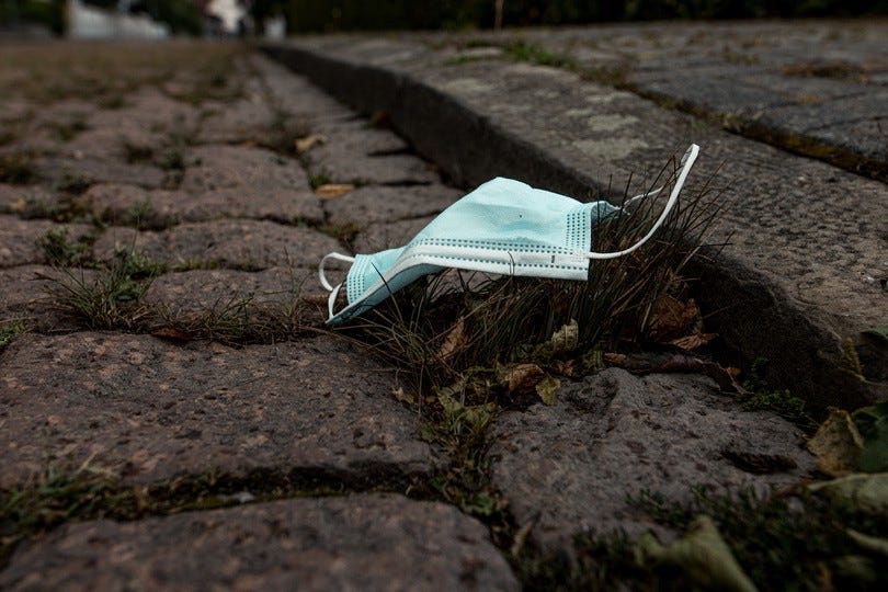 Disposed mask on a broken road