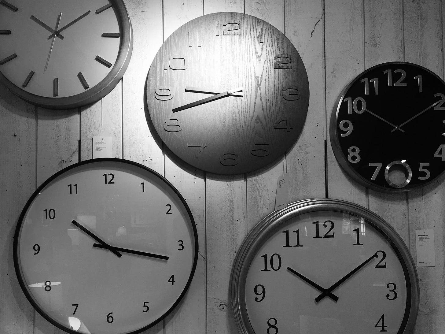 Photo of five analog clocks reporting at least three different times.