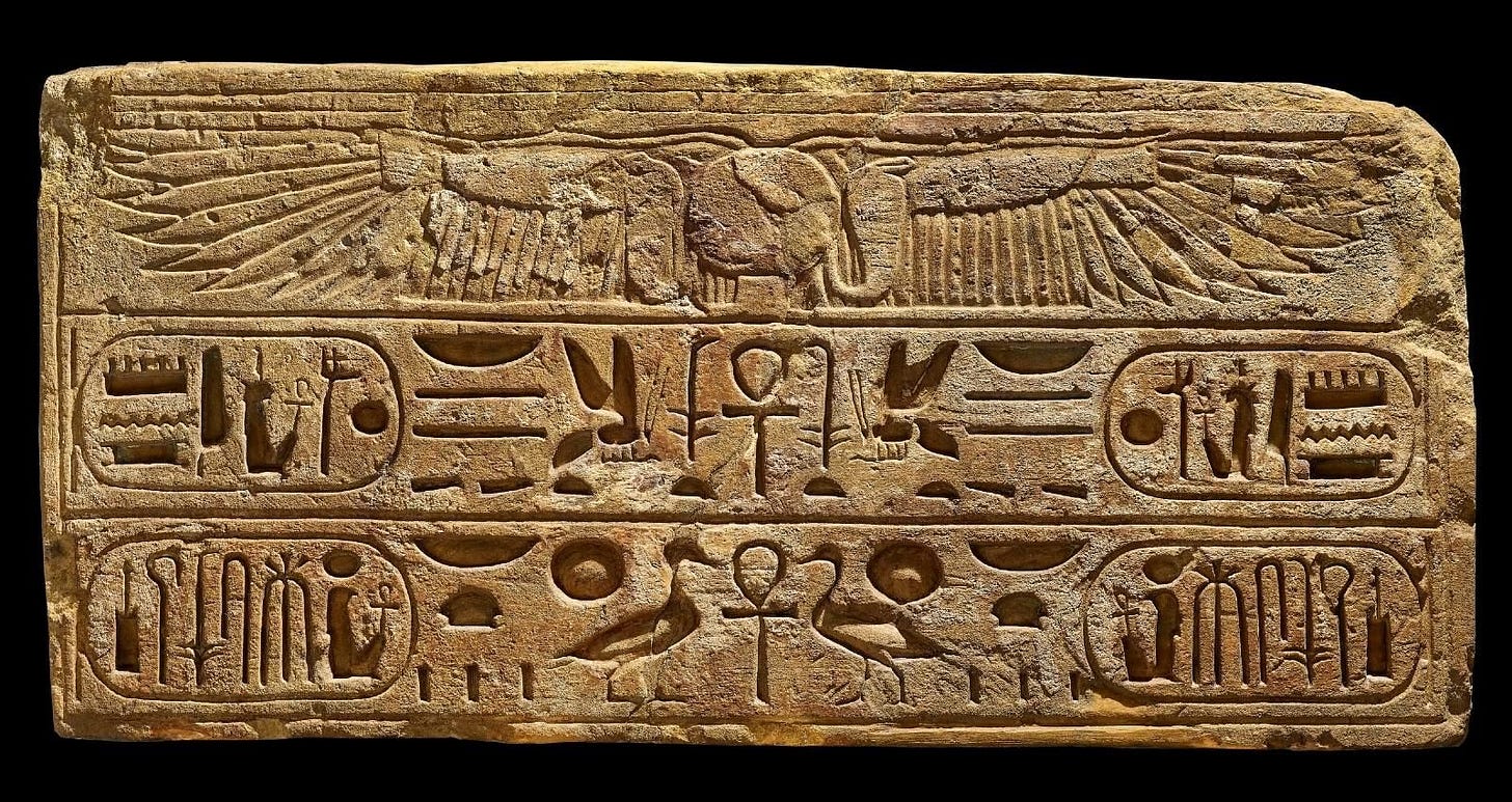 A sandy-coloured flat stone slab, engraved with hieroglyphs. 
