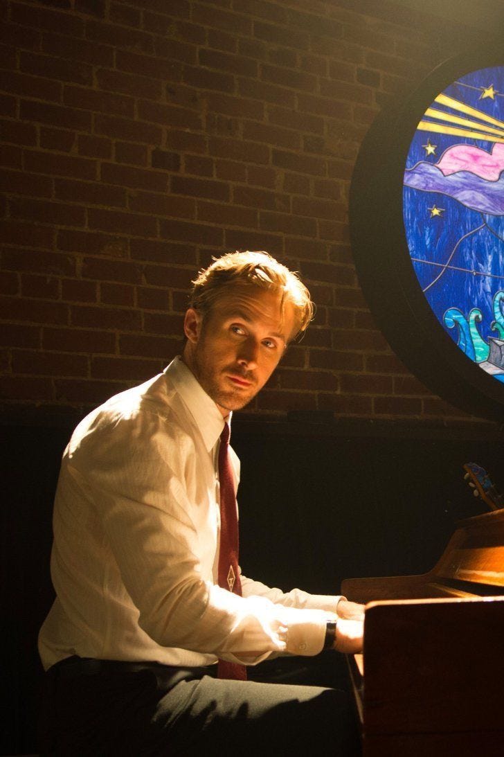 This may contain: two men sitting at a piano in front of a stained glass window with a lighthouse on it This may contain: two men sitting at a piano in front of a stained glass window with a lighthouse on it