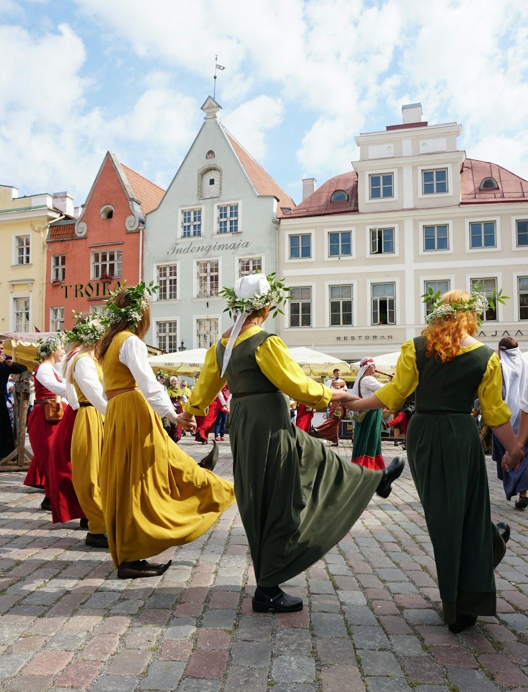 people in green and yellow dresses walking on sidewalk during daytime