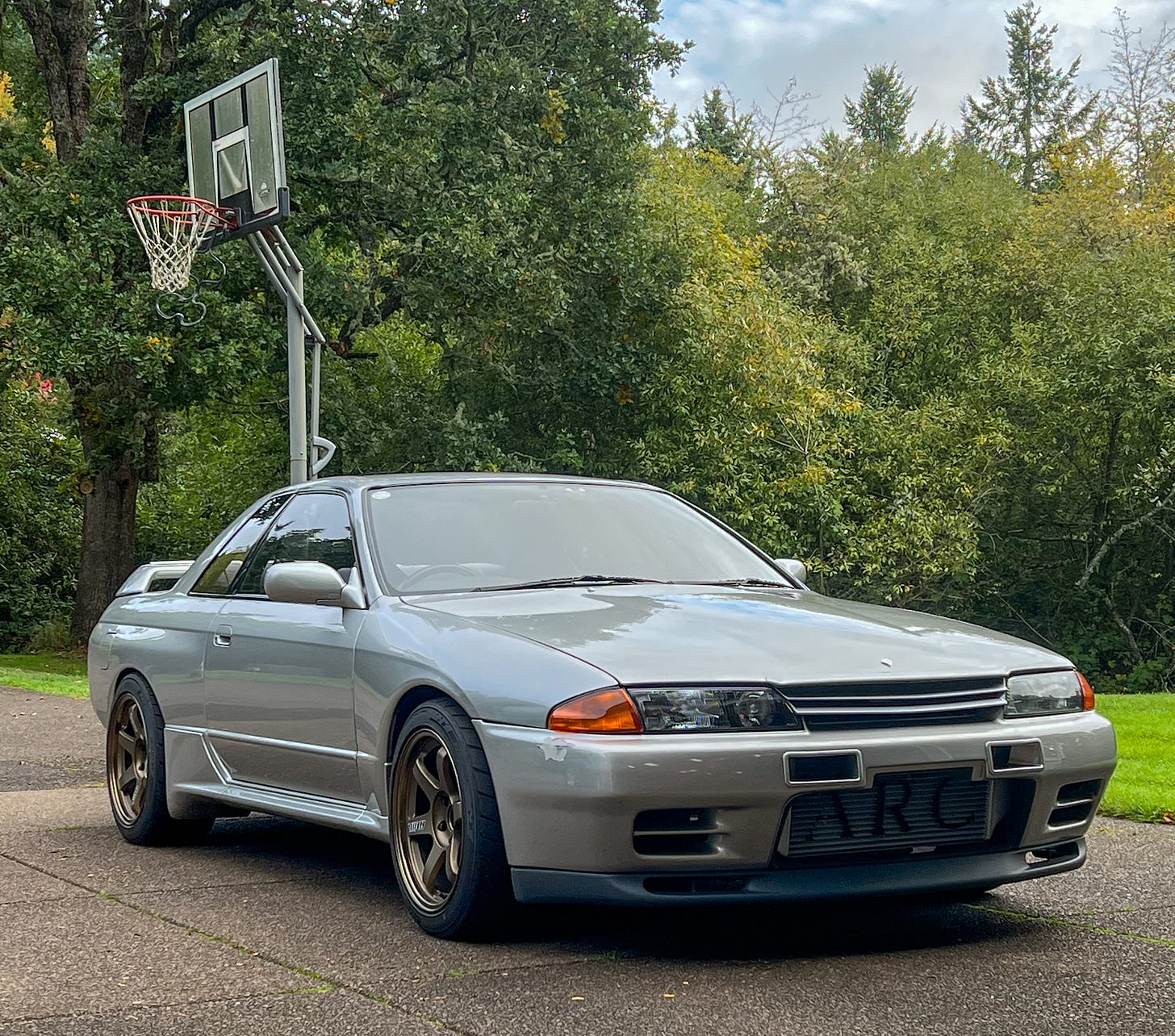 Front three-quarter view of a grey Nissan R32 Skyline GT-R once owned by MotoRex founder Hiro Nanahoshi.