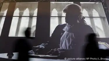 A faceless figure represents 18th century adventurer Casanova sitting at a desk, writing his memoirs. A faceless figure represents 18th century adventurer Casanova sitting at a desk, writing his memoirs.