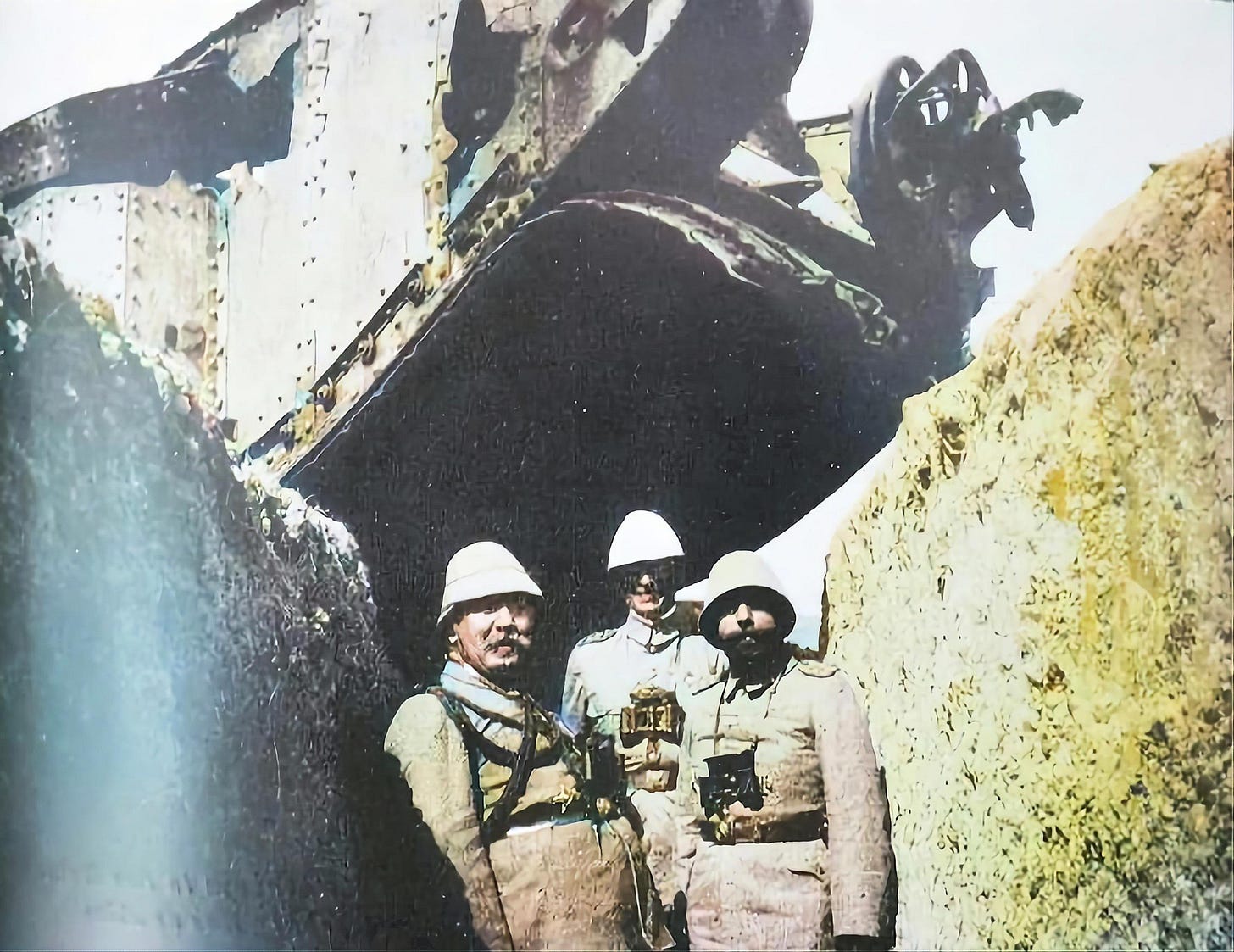 Djemal Pasha (front right) and Friedrich Von Kressenstein (front left) pose in a colorized photo, standing before a destroyed Mark 1 Tank after the Second Battle of Gaza, April 1917.