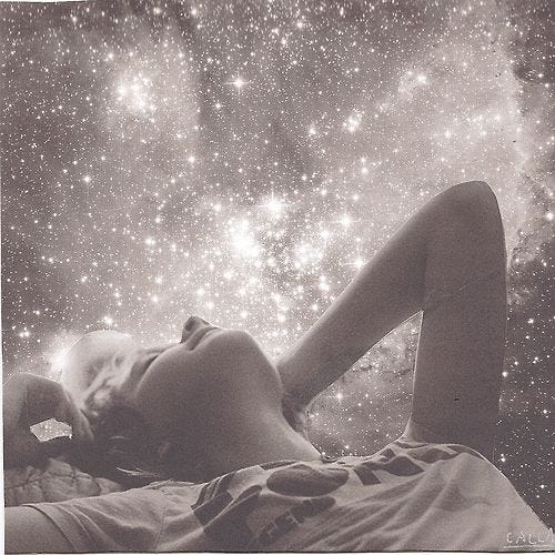This may contain: a woman laying on top of a bed under a sky filled with lots of stars This may contain: a woman laying on top of a bed under a sky filled with lots of stars