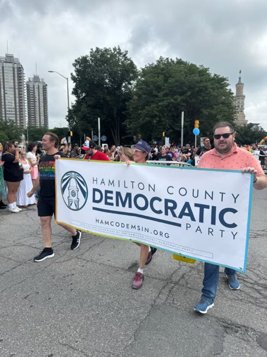Hamilton County Democrats march in Indy Pride holding a party sign