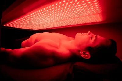 A man laying down under red light in the sun. A man laying down under red light in the sun.