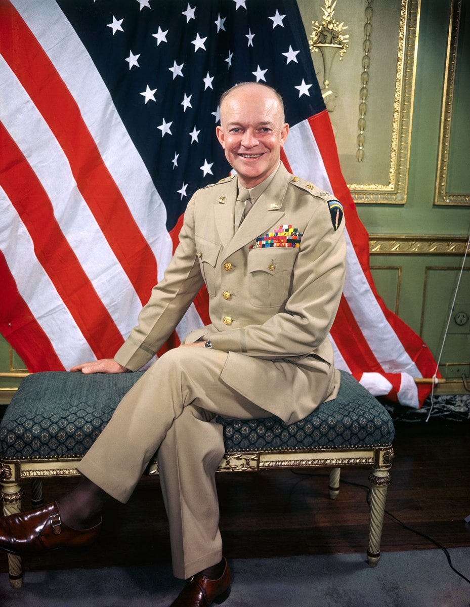 Dwight D. Eisenhower poses in front of an American flag. 19th June, 1945.