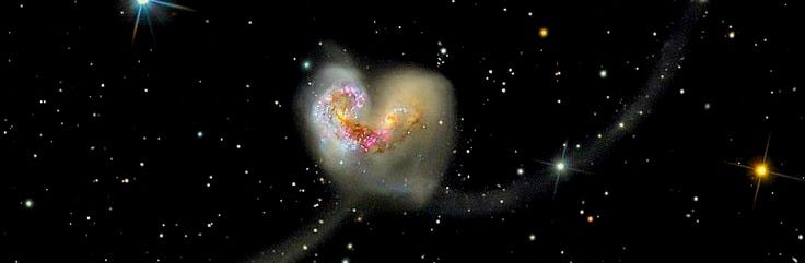 This may contain: two spiral shaped objects in the middle of a black sky filled with stars and bright lights