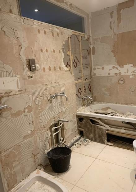 A bathroom with a tub and a bucket

AI-generated content may be incorrect.