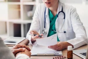 Woman doctor reviews a prescription with a patient. Courtesy of ESMT Berlin