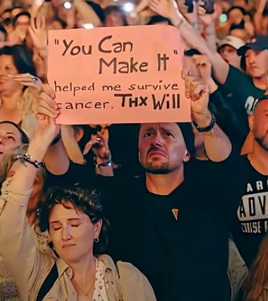 A woman's headband seems to go over the wrist of the woman in front, while her own hand morphs into the man holding up a sign
