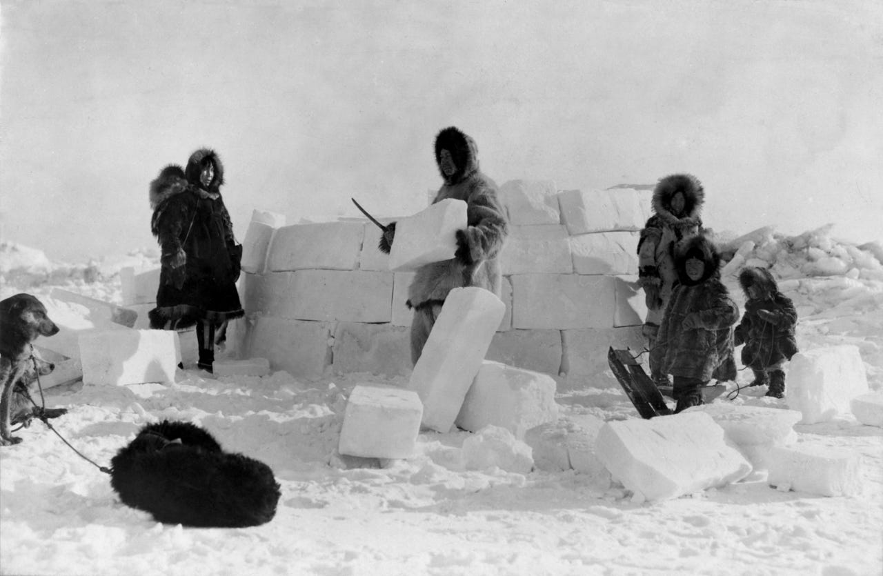Alaska natives putting together an igloo.