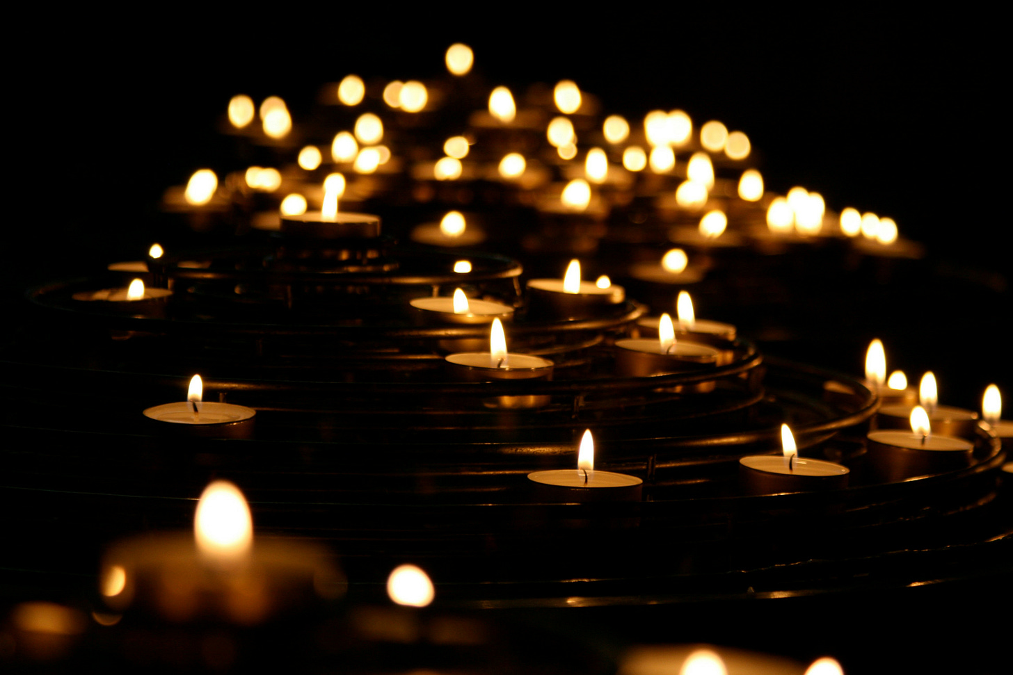 Tea light candles floating on dark water Tea light candles floating on dark water