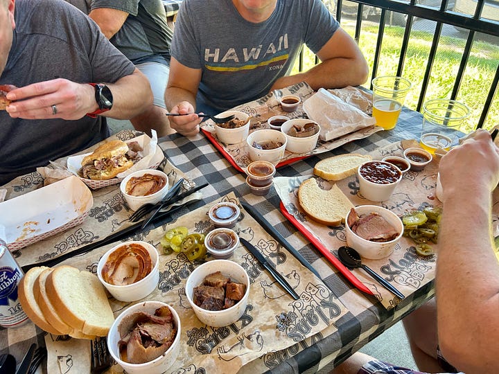 barbecue, picnic tables, signs, people in line