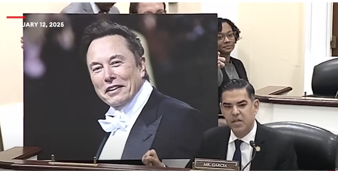 During a congressional hearing, Rep. Robert Garcia (D-California) displays a large photo of Elon Musk in a tuxedo.